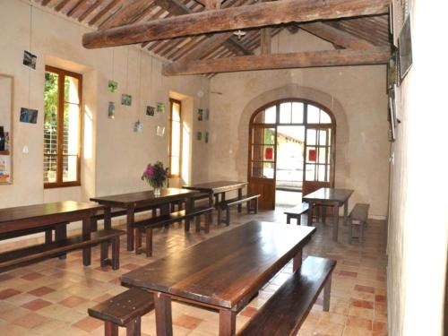 Cette grande chambre dispose de tables et de bancs en bois. dans l'établissement Distinctive tiny house in Sarrians with terrace, à Sarrians