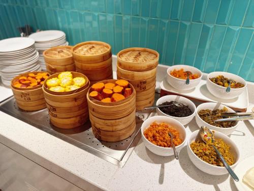 a buffet with bowls of food on a table at Hilton Garden Inn Xuzhou Pengcheng Square in Xuzhou