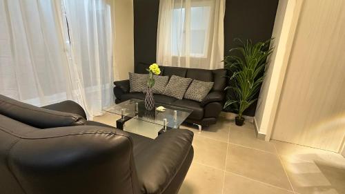 a living room with a leather couch and a table at Encanto Moderno en Punta Cana in Punta Cana