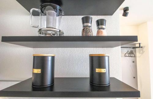 two black plates on a shelf in a kitchen at Küstenkind Dorum mit Sauna und Balkon - Hunde willkommen in Dorum