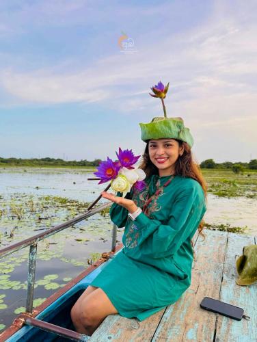 a girl in a green dress and a hat on a boat at Habarana Tree House Ambasewana Resort in Habarana