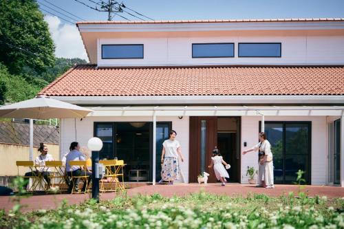 a group of people standing outside of a house at 丘の上の貸切平屋 ペンペンハウス in Nakayama