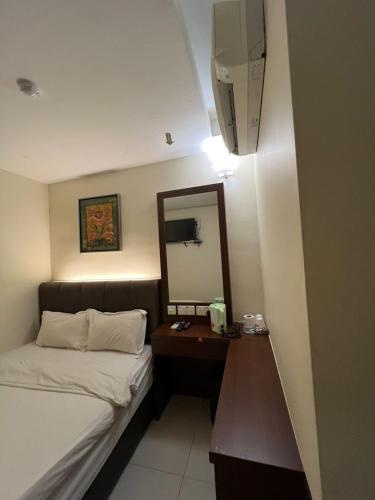 a bedroom with a bed and a vanity with a mirror at ARABIAN HOTEL Melaka in Tranquerah