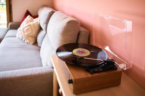 a record player on a table next to a couch at 丘の上の貸切平屋 ペンペンハウス in Nakayama