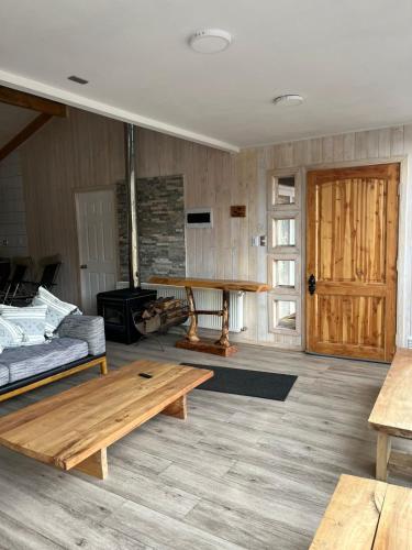 a living room with a wooden table and a couch at Refugio Sierra Nevada in Malalcahuello