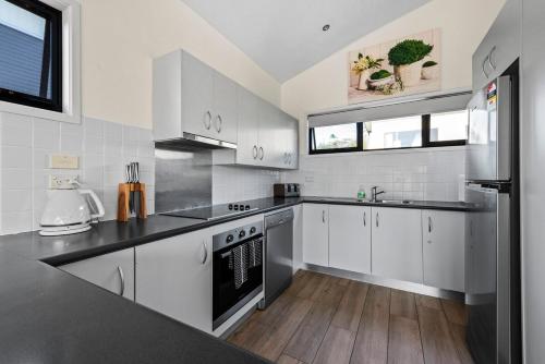 a kitchen with white cabinets and stainless steel appliances at Perfect Jervis Bay location & fresh modern living in Vincentia