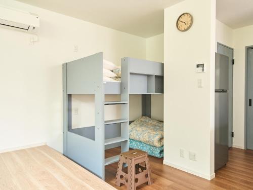 a bedroom with a bunk bed and a clock on a wall at ちょこっとヴィラMaestro in Tusi
