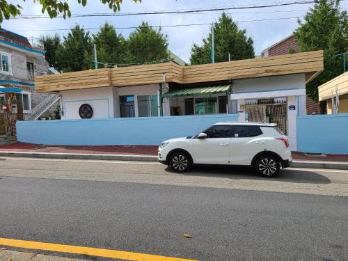 a white car parked on the side of a street at Min and Jeong House in Tongyeong