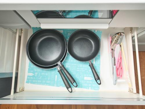 two frying pans and utensils in a drawer at ちょこっとヴィラMaestro in Tusi