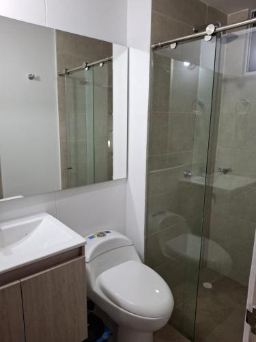 a bathroom with a toilet and a glass shower at Apartamento Cartagena cerca a la playa in Cartagena de Indias