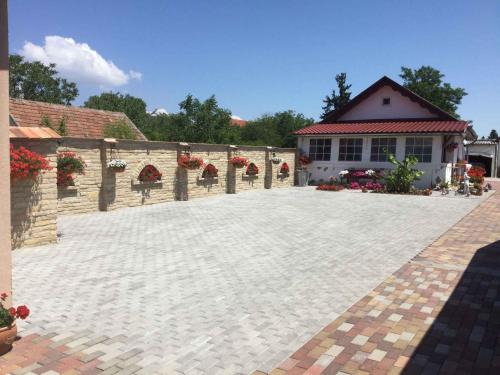 a patio with red flowers and a building at Holiday Home Balatonbereny 16 in Balatonberény