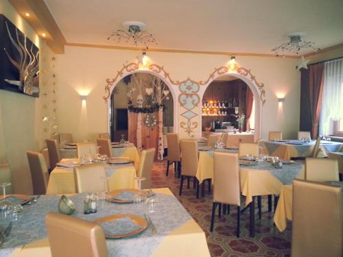 ein Restaurant mit Tischen, Stühlen und einem Spiegel in der Unterkunft Al Sole in Auronzo di Cadore