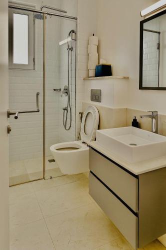 a bathroom with a toilet and a sink and a shower at Ocean crescent As sifah in As Sīfah