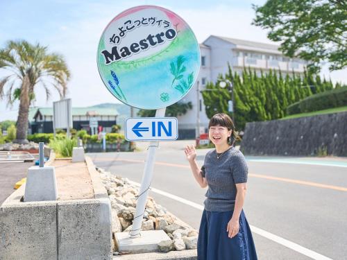 a woman standing next to a street sign at ちょこっとヴィラMaestro in Tusi