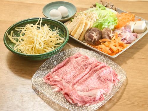 a table with plates of food and bowls of pasta at ちょこっとヴィラMaestro in Tusi