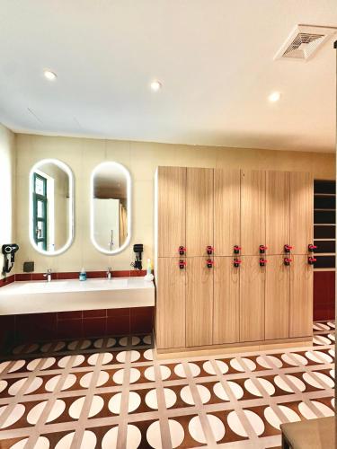 a bathroom with wooden lockers and a large mirror at Yuanjili International Youth Hostel in Qingdao