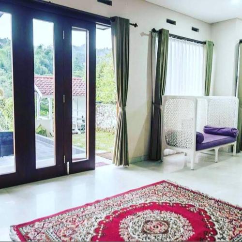 a living room with a red rug and a window at Foursya Villa Samarinda in Loa Bakong