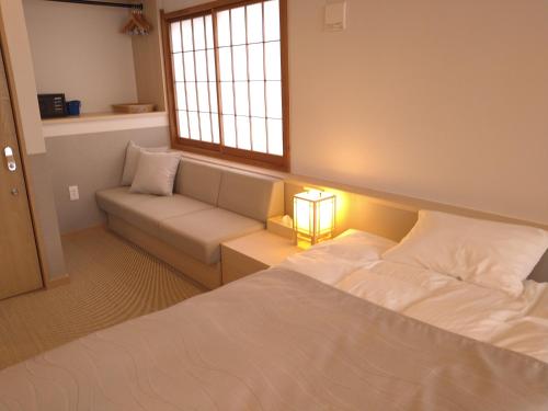 una camera da letto con un letto, un divano e una finestra di Ayameya Ryokan a Nakanojo