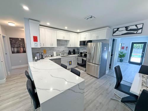 a kitchen with white cabinets and a white counter top at The LuxeLanding MIA- Swimming pool, Oasis Lounge, Mini Golf, BBQ and Hibachi Grill , and Outdoor Games in Miami