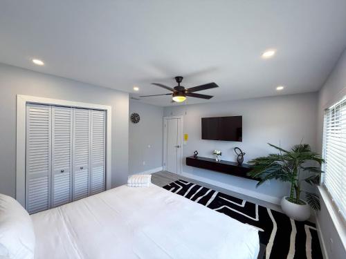 a living room with a ceiling fan and a tv at The LuxeLanding MIA- Swimming pool, Oasis Lounge, Mini Golf, BBQ and Hibachi Grill , and Outdoor Games in Miami