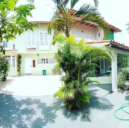 a house with a palm tree in front of it at Casa Clorophila, suíte master completa com banheira, para 3 hóspedes in Vila Velha