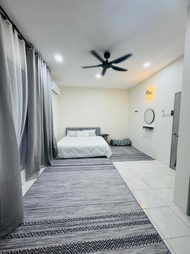 a bedroom with a bed and a ceiling fan at asaha homestay in Kepala Batas