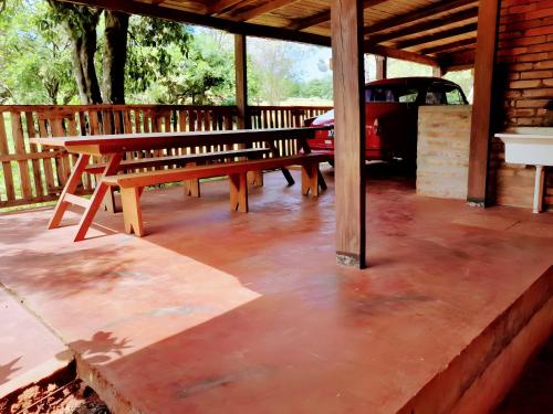 a patio with a bench and a car parked at Los Lapachos. La naturaleza es acá 