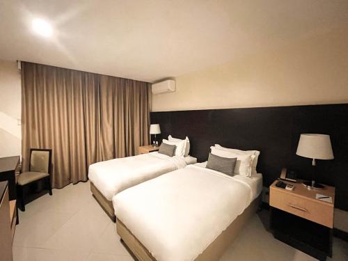 a hotel room with two beds and a window at The Lake Hotel Tagaytay in Tagaytay