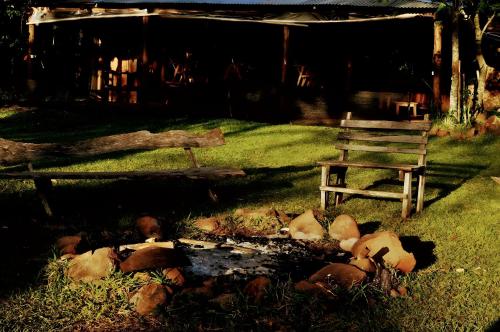a fire pit in the grass next to a bench at Los Lapachos. La naturaleza es acá 