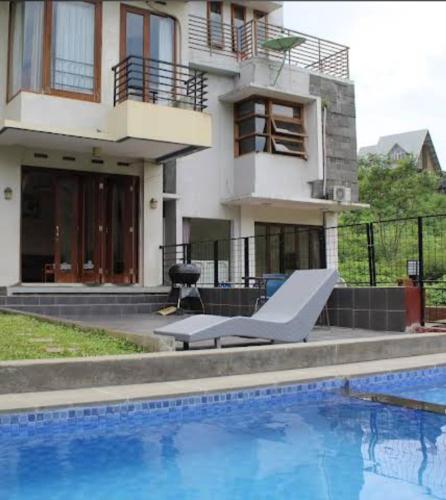 a house with a swimming pool in front of a house at Foursya Villa Samarinda in Loa Bakong