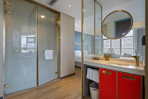 a bathroom with a red vanity and a mirror at Urba Hotel Hangzhou Sijiqing Qingchun Square Subway Station Branch in Hangzhou