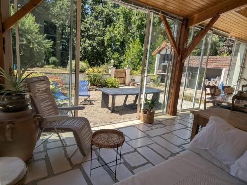 a patio with a bed and chairs and a table at Moulin Authentique avec Jardin Privé et Activités pour Familles et Amis en Bord de Rivière - FR-1-653-251 in Saint-Mary
