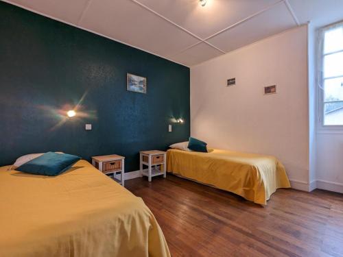 a room with two beds and a green wall at Moulin Authentique avec Jardin Privé et Activités pour Familles et Amis en Bord de Rivière - FR-1-653-251 in Saint-Mary