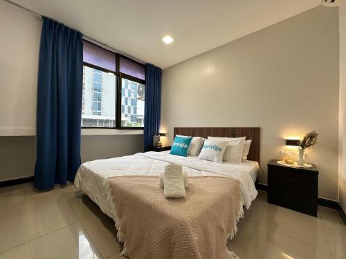 a bedroom with a large bed with blue curtains at Homigo - PWTC in Kuala Lumpur