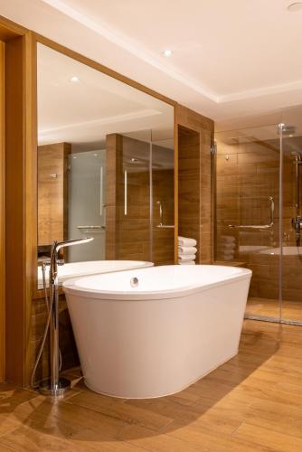 a white bath tub in a bathroom with a mirror at Hyatt Regency Kuantan Resort in Kuantan
