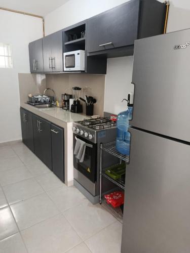 a kitchen with a stove and a refrigerator at Departamento "Mar & Descanso" in Ciudad Madero