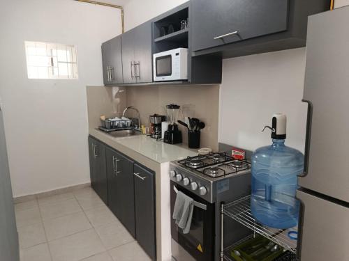 a kitchen with a black stove and a refrigerator at Depto Vacacional Playa in Ciudad Madero