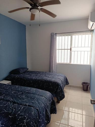 a bedroom with two beds and a ceiling fan at Departamento "Mar & Descanso" in Ciudad Madero