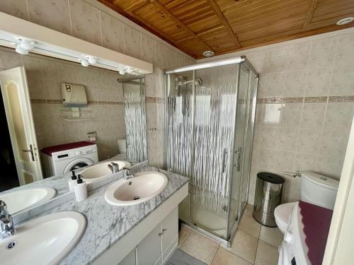 une salle de bain avec deux lavabos et une douche dans l'établissement Maison T4 avec Garage et WiFi à 300m de la Plage - Quartier Arago - FR-1-92-655, à Les Sables-dʼOlonne