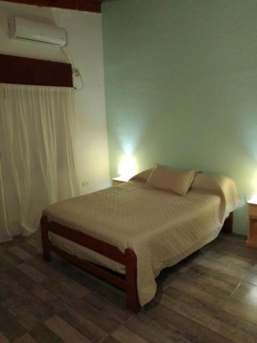 a bedroom with a bed with two lamps on it at Casa de campo - PetFriendly in Concepción del Uruguay
