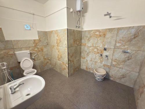 a bathroom with a sink and a toilet and a shower at RITU CAPITOL Homestay in Trivandrum