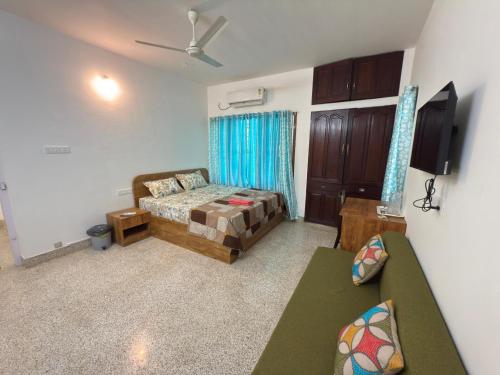 a living room with a bed and a couch at RITU CAPITOL Homestay in Trivandrum