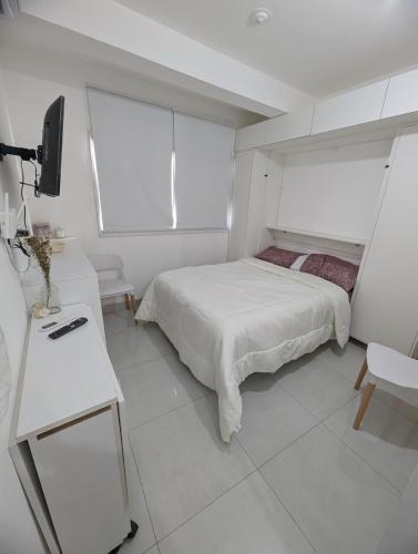 a white bedroom with a bed and a desk at Mono ambiente Rest in Santiago del Estero