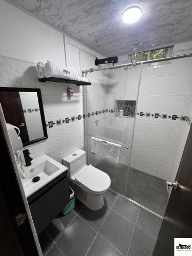 a bathroom with a shower and a toilet and a sink at Estrato6 Apart Studios in Villanueva