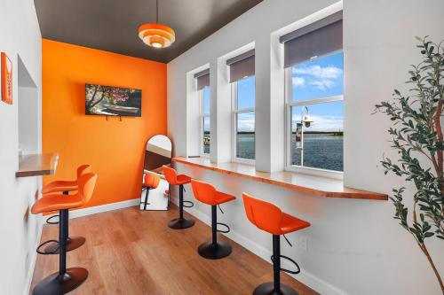 a bar with orange chairs in a room at On The Dock by Westlynn in Little Current