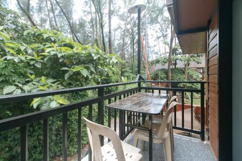 a balcony with a table and chairs and trees at RedDoorz @ Dolce Cabanas Beach Resort in Zambales