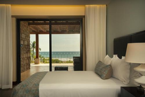 a bedroom with a bed with a view of the ocean at Crocs Resort & Casino in Jacó