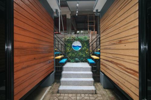 a hallway with stairs with chairs and a blue umbrella at RedDoorz @ Dolce Cabanas Beach Resort in Zambales