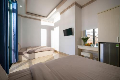 a living room with a bed and a television at AN Boutique Hotel in Da Lat