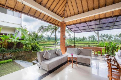 an outdoor living room with a couch and a table at Tanta Escape in Tegalalang